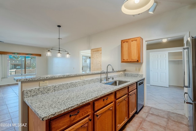 kitchen with sink, light stone counters, pendant lighting, light tile patterned flooring, and appliances with stainless steel finishes