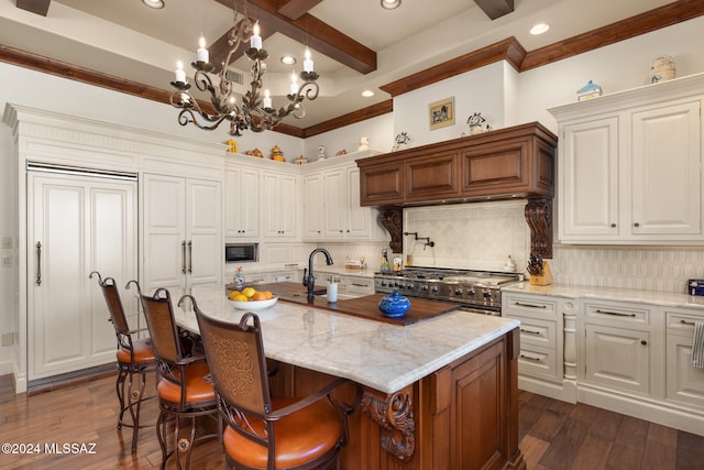 kitchen with a notable chandelier, a center island with sink, dark hardwood / wood-style floors, and appliances with stainless steel finishes