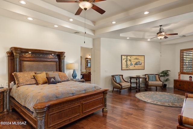 bedroom with dark hardwood / wood-style floors, ceiling fan, and a tray ceiling