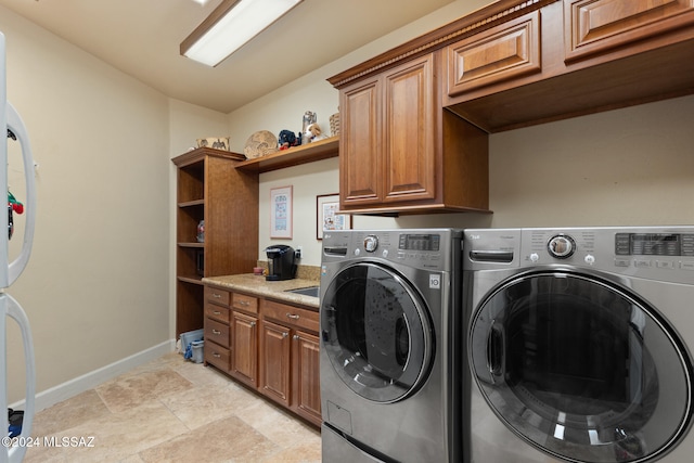 clothes washing area with cabinets and separate washer and dryer