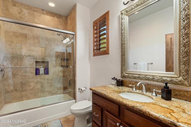 full bathroom featuring tile patterned floors, toilet, combined bath / shower with glass door, and vanity