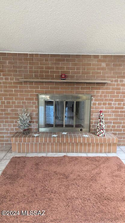 room details featuring a textured ceiling and a brick fireplace