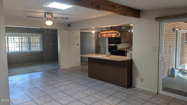 kitchen featuring kitchen peninsula, a textured ceiling, ceiling fan, black appliances, and beam ceiling