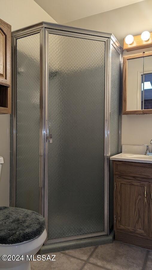 bathroom with walk in shower, tile patterned floors, vanity, and toilet