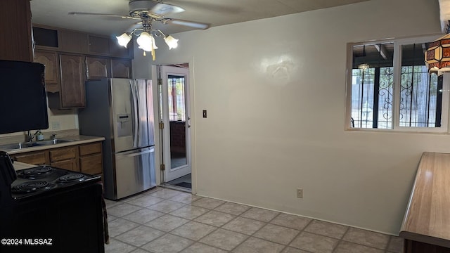 kitchen with stainless steel refrigerator with ice dispenser, plenty of natural light, black / electric stove, and sink