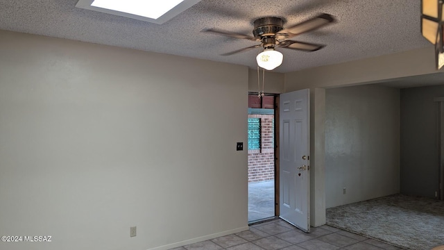 tiled empty room featuring a textured ceiling and ceiling fan