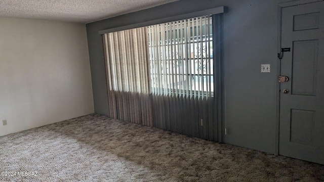 carpeted foyer entrance featuring a textured ceiling