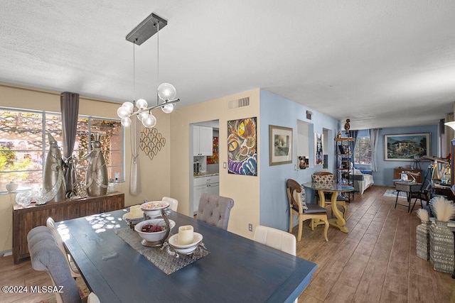 dining area with an inviting chandelier and hardwood / wood-style flooring