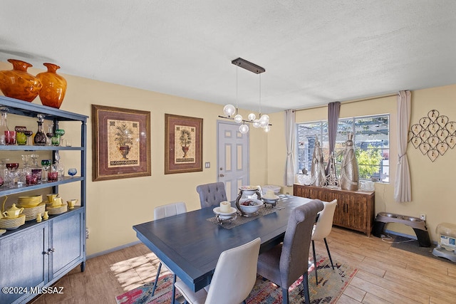 dining area featuring a textured ceiling and light hardwood / wood-style flooring