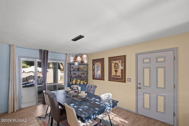 dining space featuring light wood-type flooring and an inviting chandelier