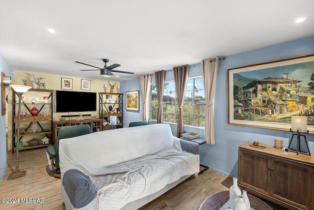 living room with light wood-type flooring and ceiling fan