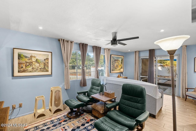 living area featuring ceiling fan, plenty of natural light, and light hardwood / wood-style flooring