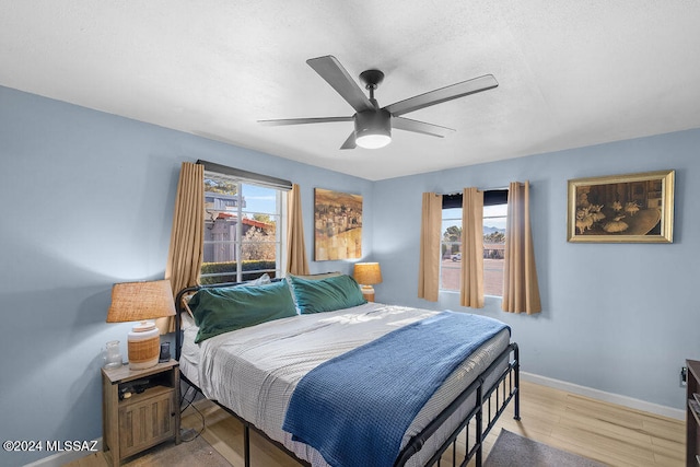 bedroom featuring multiple windows, ceiling fan, and light hardwood / wood-style floors