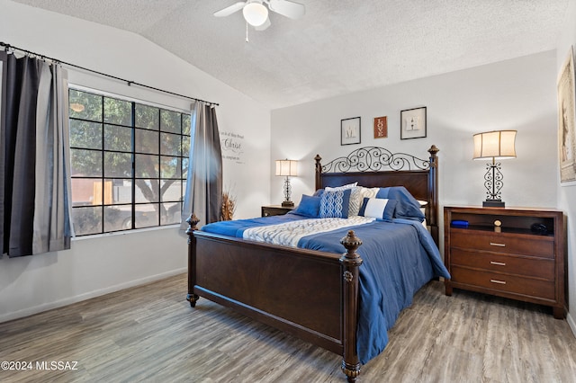 bedroom featuring hardwood / wood-style flooring, ceiling fan, lofted ceiling, and a textured ceiling