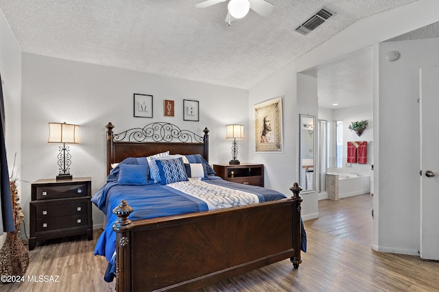 bedroom with hardwood / wood-style flooring, ceiling fan, a textured ceiling, and connected bathroom