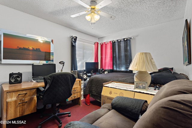 office area featuring a textured ceiling, dark carpet, and ceiling fan