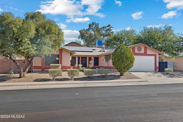 single story home with solar panels and a garage