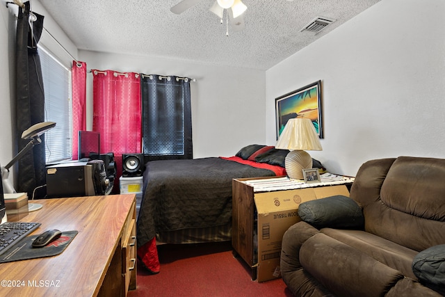 carpeted bedroom featuring ceiling fan and a textured ceiling