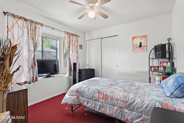 carpeted bedroom featuring ceiling fan, a textured ceiling, and a closet