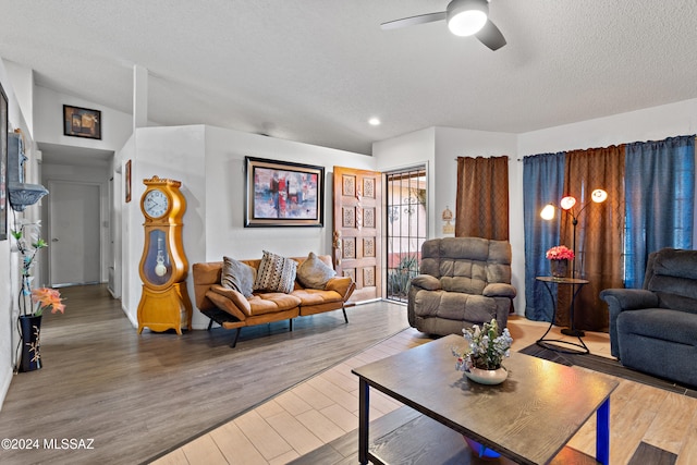 living room with a textured ceiling, hardwood / wood-style flooring, and ceiling fan