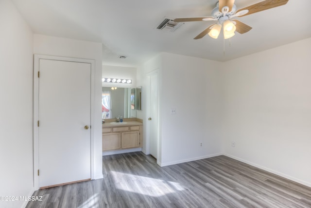 unfurnished bedroom with ceiling fan, light hardwood / wood-style floors, sink, and connected bathroom