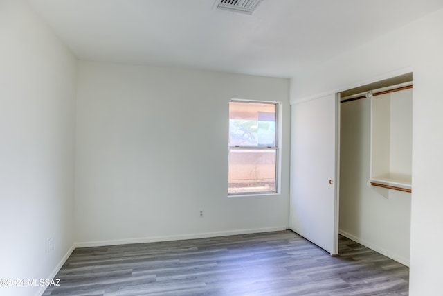 unfurnished bedroom with a closet and hardwood / wood-style floors