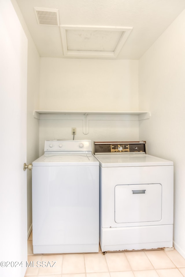 washroom featuring washing machine and dryer and light tile patterned floors