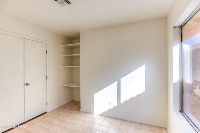 unfurnished bedroom with a closet and light tile patterned floors