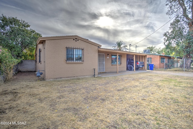 back of house featuring a yard and a carport