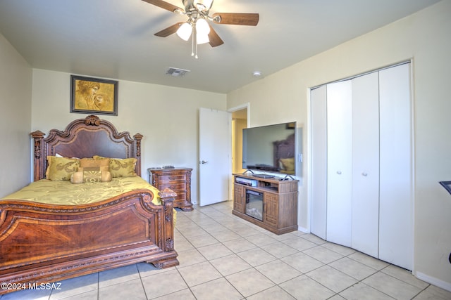 bedroom featuring ceiling fan, light tile patterned floors, and a closet