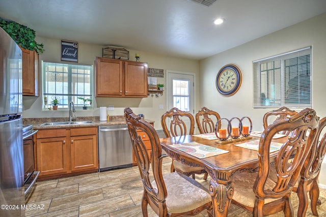 dining room with a wealth of natural light, sink, and light wood-type flooring