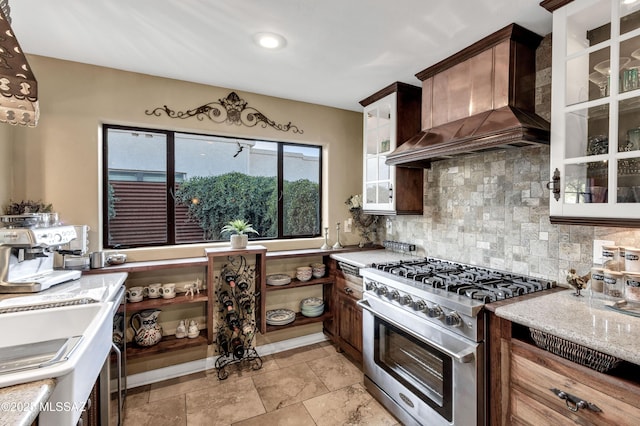 kitchen with decorative backsplash, custom range hood, high end stove, and dark brown cabinets