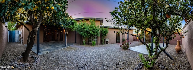 yard at dusk featuring a patio