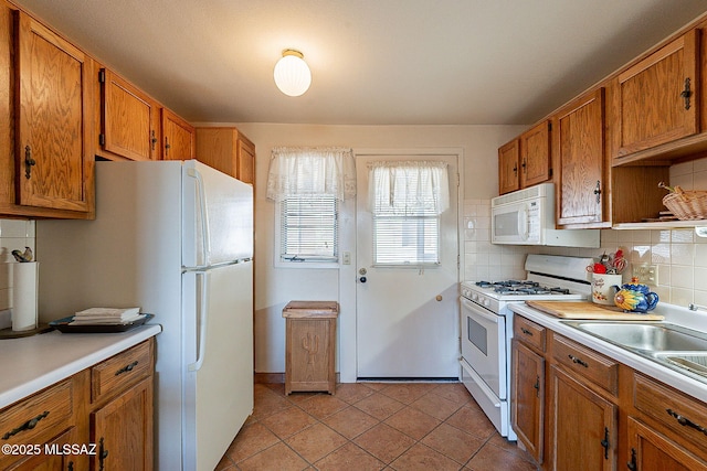 kitchen featuring white appliances, tasteful backsplash, and light tile patterned flooring