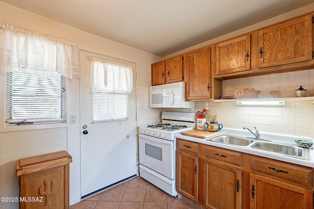 kitchen with decorative backsplash, white appliances, sink, and light tile patterned floors