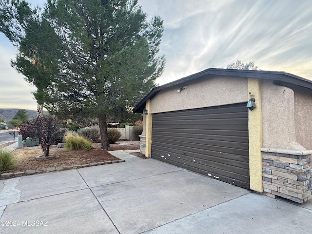 view of garage at dusk