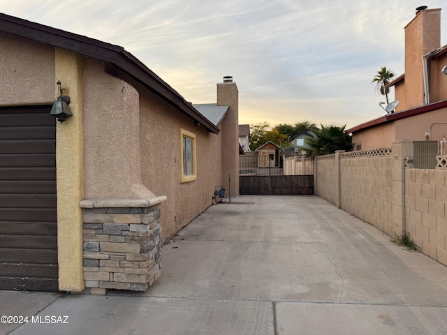 property exterior at dusk featuring a patio area