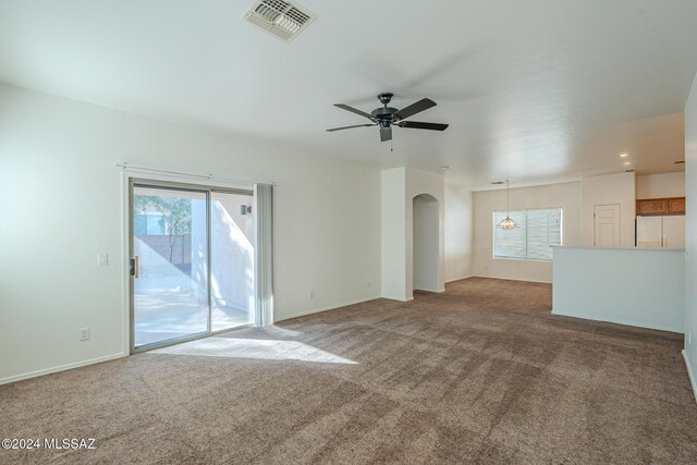 spare room with light colored carpet, plenty of natural light, and ceiling fan