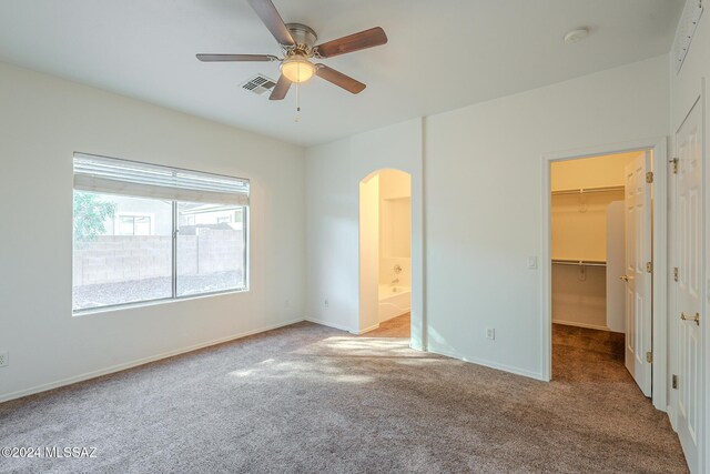 unfurnished bedroom with ensuite bath, ceiling fan, and light colored carpet