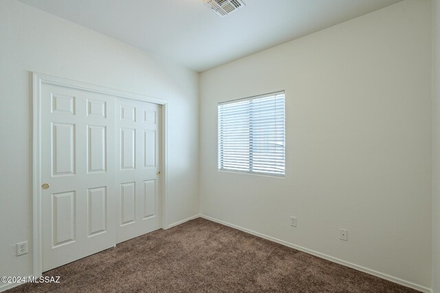 unfurnished bedroom featuring carpet floors and a closet