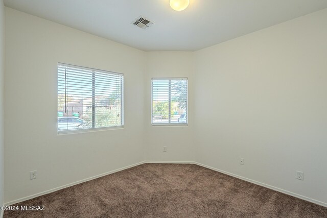 unfurnished bedroom featuring dark colored carpet and a closet