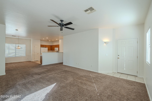 unfurnished living room with ceiling fan and light colored carpet