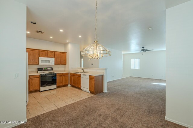 kitchen featuring kitchen peninsula, white appliances, sink, and light tile patterned floors