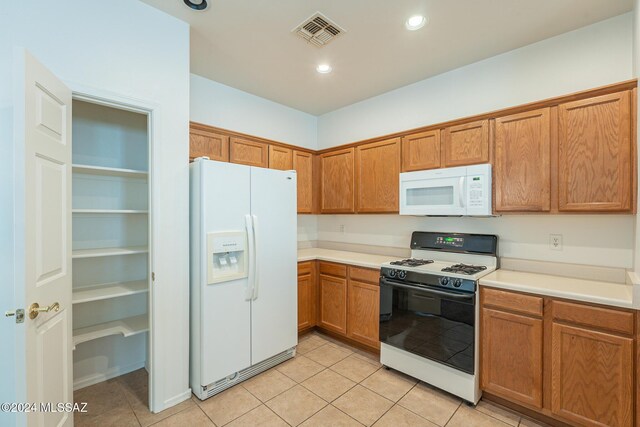 kitchen featuring a chandelier, white fridge with ice dispenser, light colored carpet, and hanging light fixtures