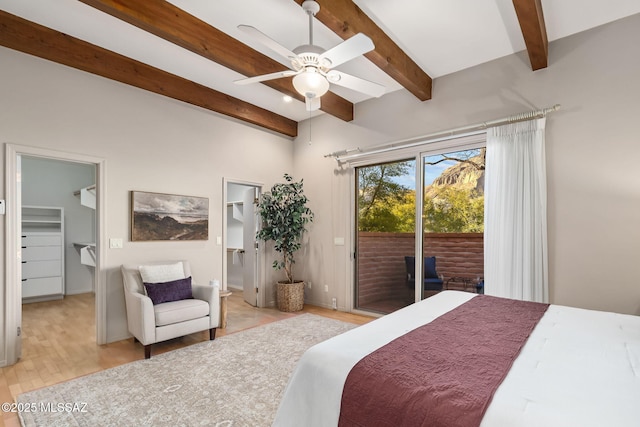 bedroom featuring a spacious closet, light wood-style flooring, beam ceiling, and access to exterior