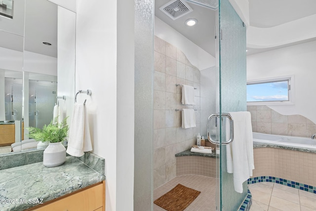 bathroom with a garden tub, a shower stall, visible vents, and vanity