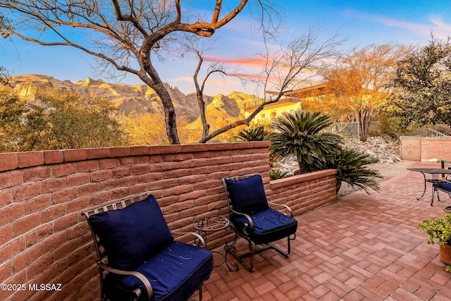 view of patio with a mountain view and fence