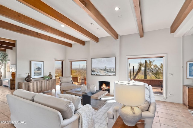 living room featuring recessed lighting, a warm lit fireplace, beam ceiling, and light tile patterned floors