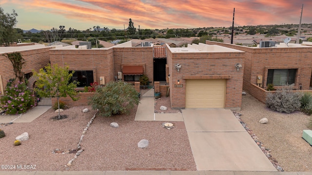 view of front of home featuring central AC and a garage