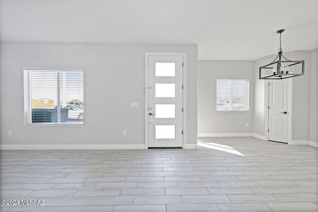 entrance foyer with light hardwood / wood-style flooring and an inviting chandelier